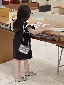Close-up of holographic silver quilted crossbody bag for kids with metallic chain strap