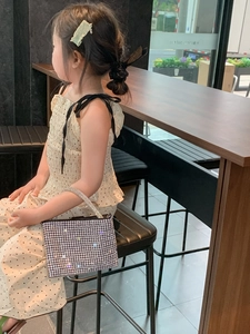 Close-up of children's square handbag with silver rhinestones and crystal chain handle