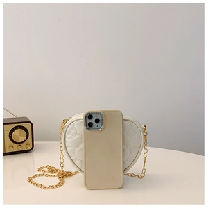 White heart-shaped quilted bag with gold chain strap shown next to a smartphone for scale