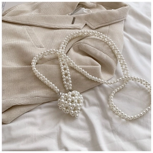 Détail de la bandoulière en perles faites main avec pendentif cœur tissé élégant
