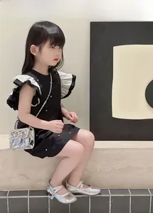 Kids silver metallic quilted crossbody bag styled with a chic black pearl dress