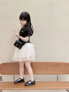 Fashionable girl wearing a black t-shirt with bow and a white layered tulle skirt