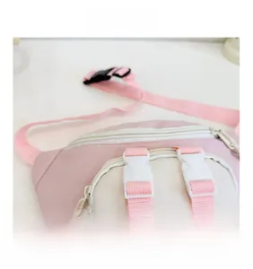 Detail of pink and beige kids chest bag featuring plastic buckle and OL B letter print