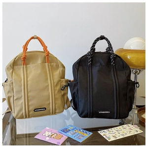 Nahaufnahme eines Nylon-Schulrucksacks mit gewebten Griffen und modischem Lederaufnäher