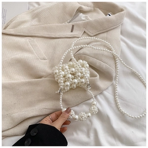 Detail of handcrafted cream pearl woven mini square bag with elegant bead texture