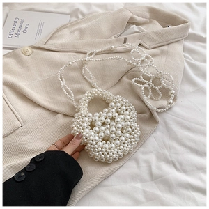 Close-up of handmade cream pearl beaded handbag with flower shape and shoulder strap