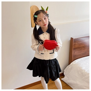 Close-up of red heart-shaped quilted crossbody bag with gold chain strap for kids