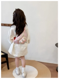 Pink and beige color-block kids chest bag shown from behind on a young model