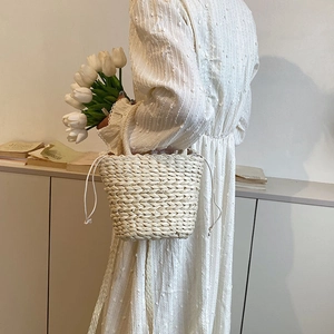 Women's woven straw bucket bag with drawstring liner for summer beach vacations