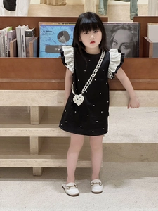 Vue détaillée de la robe noire pour fille avec volants blancs et perles décoratives