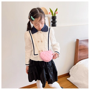 Girl wearing a pink heart-shaped quilted shoulder bag with a stylish metal chain strap