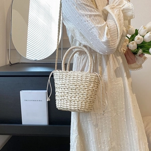 Straw bucket bag for women featuring woven handles and a drawstring liner for summer