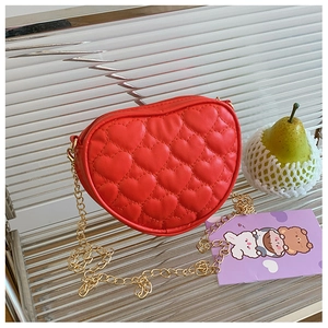 Detail of red heart-shaped quilted handbag with elegant gold metal chain strap for kids