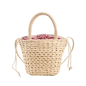 Handwoven straw bucket bag for women with red striped lining and drawstring closure