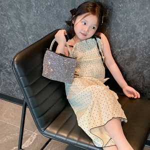 Girl wearing a silver rhinestone chain handbag with minimalist fashion dress in studio