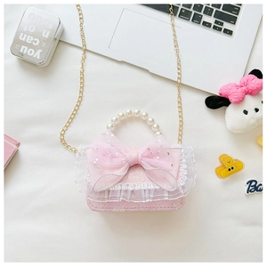 Detail of pink lace girls handbag with large bow, pearl handle and gold chain