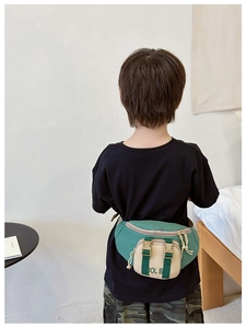 Rear view of a kids nylon waist bag in retro green and beige color block on a child