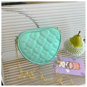 Detail of mint green heart-shaped crossbody bag with quilted stitching and gold chain strap