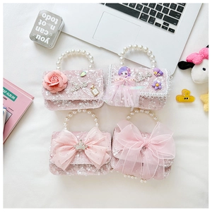 Detail of girls' mini pearl handle handbags with pink sequins and lace bow accents