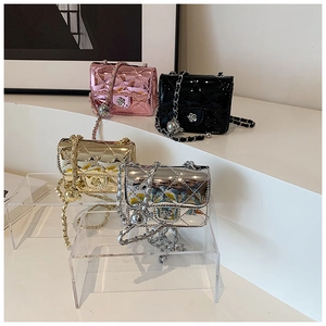 Detail showing laser finish mini bags in pink, black, gold, and silver on display