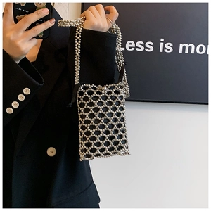 Detail of silver beaded mesh crossbody bag with black lining and long shoulder strap