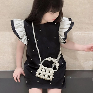 Fashionable girls' black sleeveless dress with white ruffles and a pearl crossbody bag