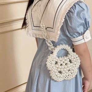 Girl wearing a white handmade pearl crossbody bag in cute flower shape with a long strap