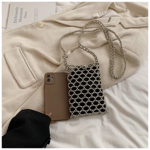 Detail of silver beaded crossbody bag with woven texture and matching strap
