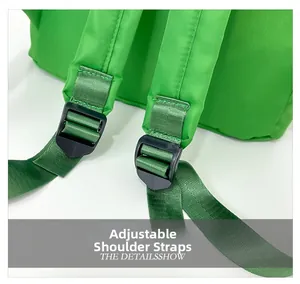 Detail of adjustable shoulder strap with durable plastic buckle on green nylon backpack