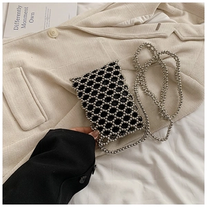 Detailed view of silver beaded crossbody bag with mesh pattern on beige corduroy suit