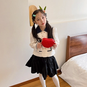 Kids quilted heart crossbody bag paired with elegant white tweed jacket and pleated skirt