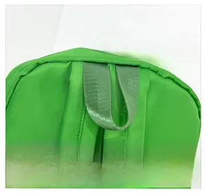 Detail of green nylon backpack showing reinforced carry handle and durable stitching