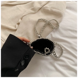 Detail of a mini silver beaded handbag with metallic mirror finish and black lining
