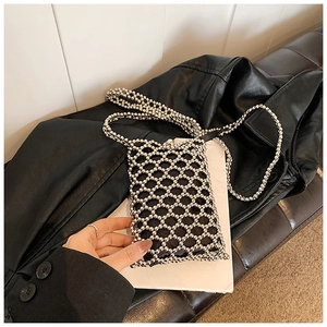 Detailed view of silver bead woven crossbody bag with hollow diamond grid and black lining