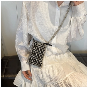 Detail of handmade beaded crossbody bag featuring black and silver diamond mesh texture