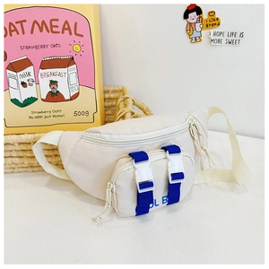 Detailed close-up of cream canvas kids chest bag with blue strap and dual buckles