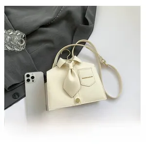 Detail of off-white PU leather crossbody bag featuring creative shirt collar and tie design