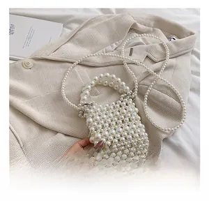 Detail view of woven pearl crossbody bag with beaded top handles and long shoulder strap