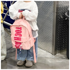 Rear view of a pink school backpack with bold letter prints worn by a child in daily use
