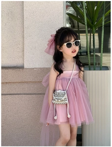 Detailed view of pink mesh dress with matching oversized bow headband and pearl mini bag
