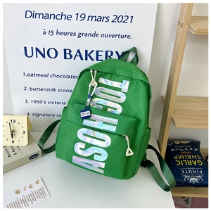 Detail of green student backpack with metallic TOO HOT lettering and stylish blue tag