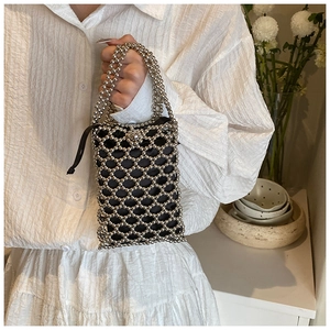 Detail of silver beaded handbag featuring a geometric woven mesh with black drawstring liner