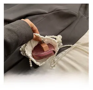 Detail view of mini pearl drawstring bag interior showing lipstick and wallet storage