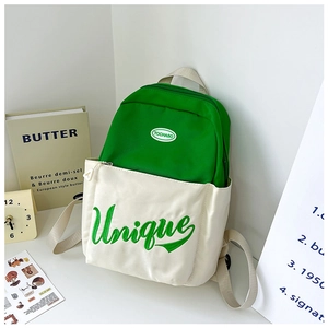 Detail of green and white backpack showing Unique embroidery and brand logo on front