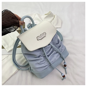 Detail of light blue and beige pleated backpack with drawstring and metal Fashion BAG tag