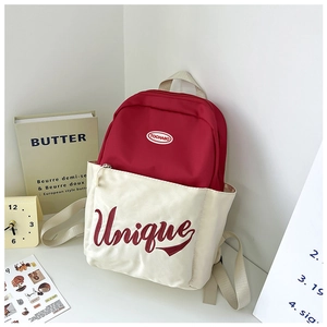 Detail of red and white contrast kids backpack with unique embroidery and round logo