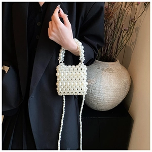 Close-up of handmade white pearl mini bag with elegant beaded strap and handle details
