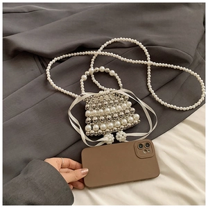 Close-up of pearl beaded mini bag featuring satin drawstring and delicate ribbon bows