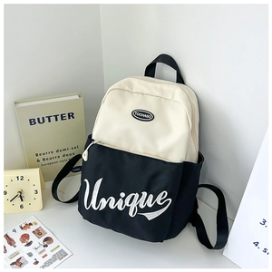 Detail of black and white contrast backpack with embroidered lettering and side pocket