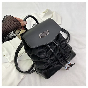 Detail of black backpack with pleated texture, drawstring closure, and colorful beads